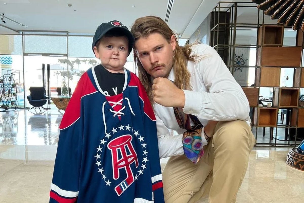 Hasbulla posing with Barstool Sports Interviewer Caleb Pressley, wearing a Barstool Sports jersey.