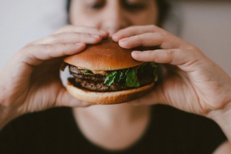 A person eating a hamburger.