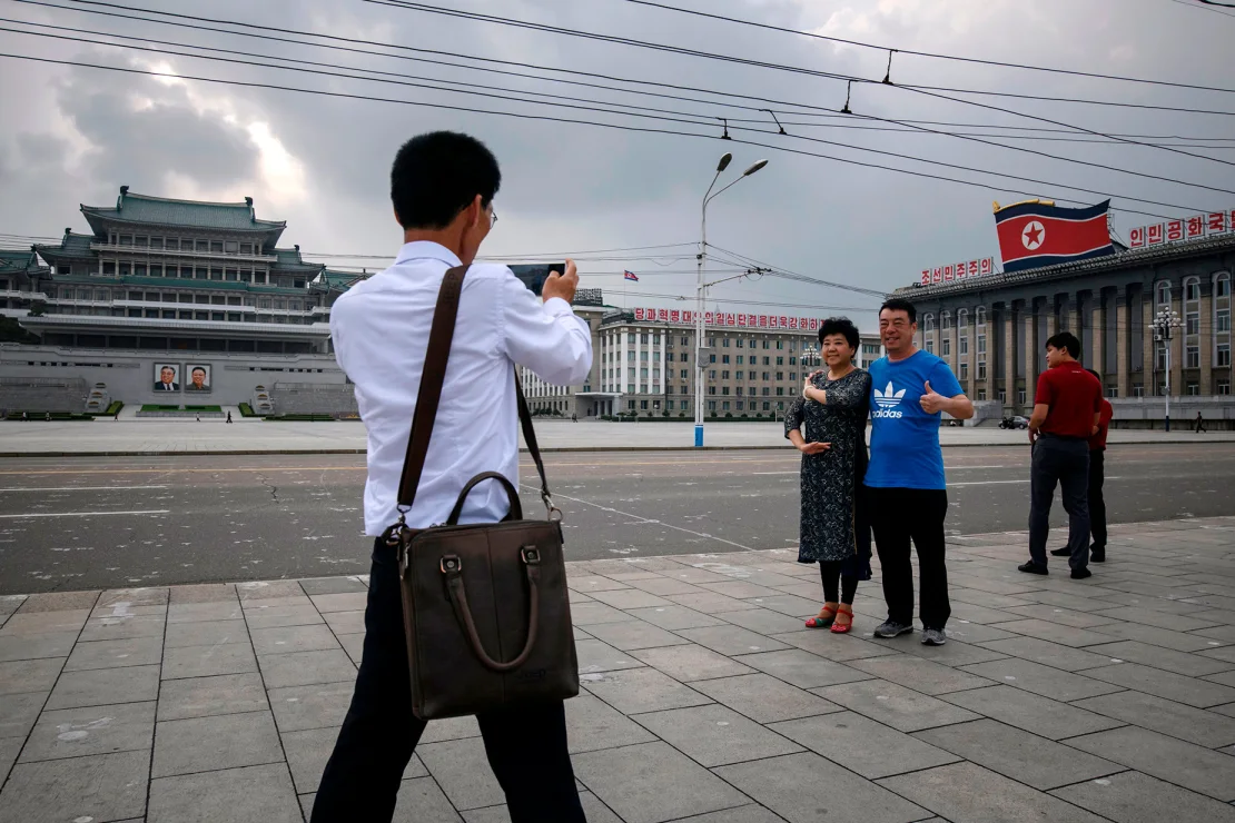 Chinese tourists pose for photos on Kim Il Sung Square in 2019